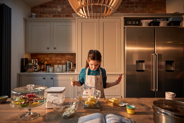 Medir qué cantidad de ingredientes necesitas es una gran forma de empezar a planear tus comidas de forma inteligente. Persona midiendo qué cantidad de ingrediente necesita para planear una comida.