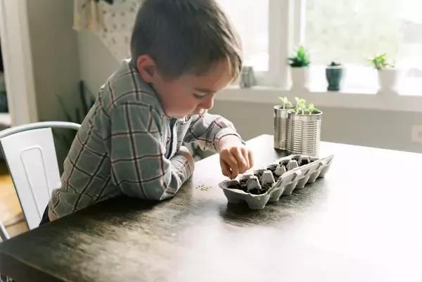 Niño pensando cómo hacer una maceta con botellas
